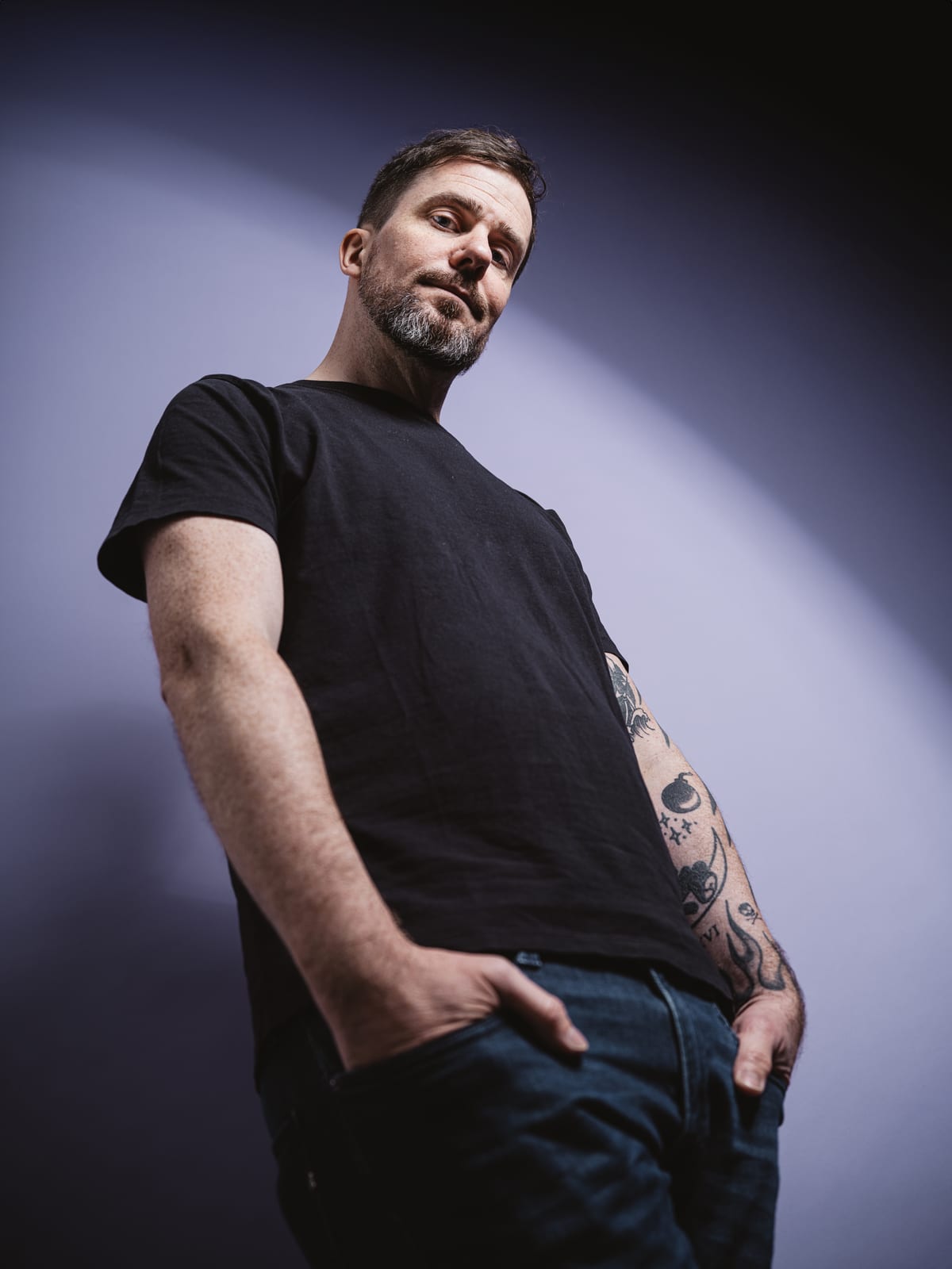 Low-angle portrait of Christoph Landes against a violet background